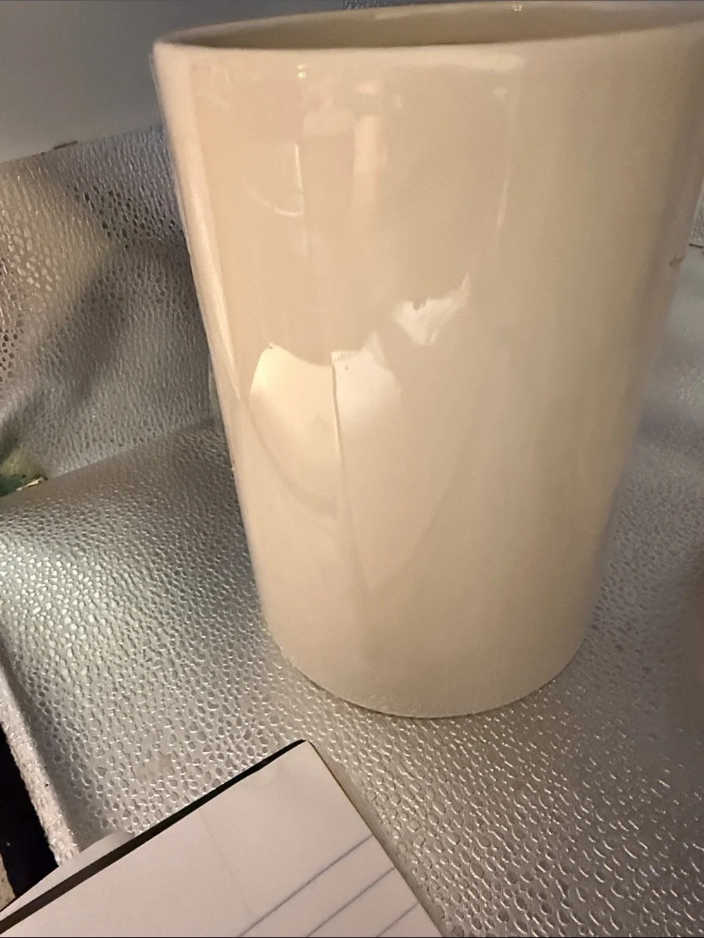 Vintage cylindrical Pier 1 cream canister with a hand painted green leaf